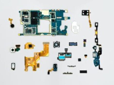 A flat lay of various electronic components, including circuit boards, sensors, and connectors, arranged neatly on a light background, illustrating building blocks of firmware and software.