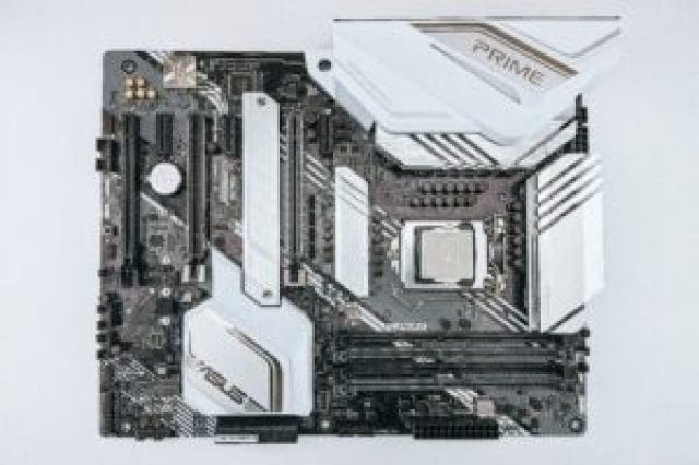 A black and white computer motherboard with various slots, connectors, and a central CPU socket, featuring sleek design elements and heat spreaders.