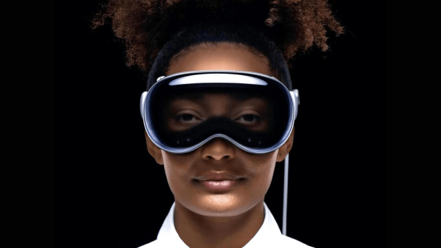 A person with curly hair wears a futuristic headset, featuring a sleek design with a dark visor, set against a black background. Their expression is calm and focused.